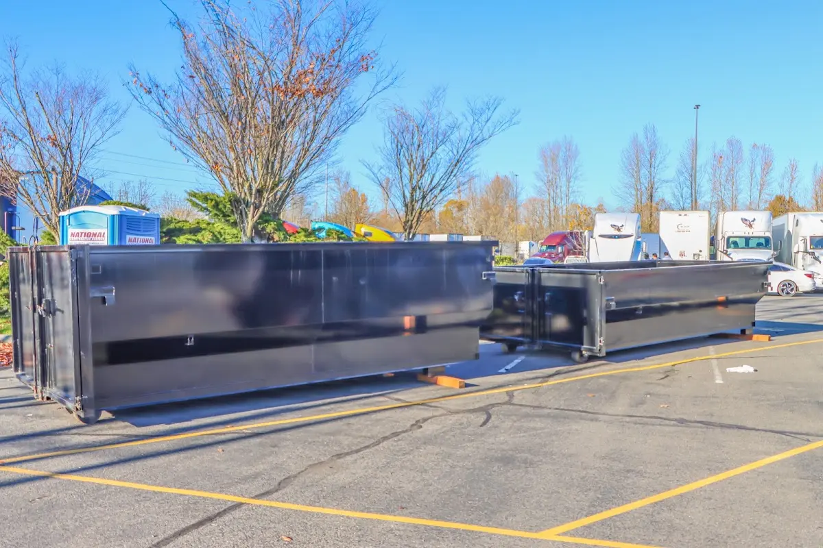 Professional dumpster rental service with roll-off container on residential driveway in Paw Paw